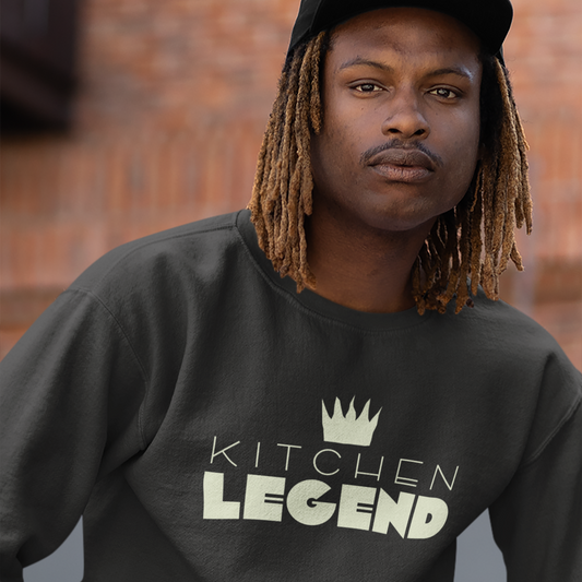 Man in a gray sweatshirt that says Kitchen Legend with a hand drawn illustration of a chef's toque